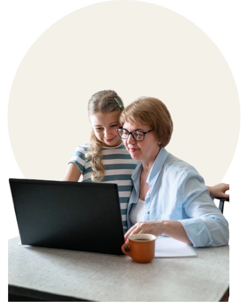Grandmother and granddaughter using a laptop together.